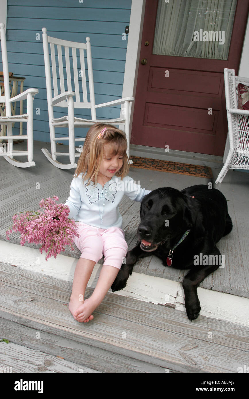 Virginia Loudoun County, Round Hill, ragazza ragazze, giovani giovani giovani giovani giovani giovani giovani giovani ragazze bambini bambini bambini femmina, fiori, portico, sedia a dondolo, cane Foto Stock