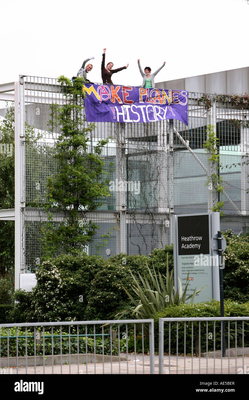 Il cambiamento climatico manifestanti appendere un banner adiacente all'aeroporto di Heathrow Foto Stock