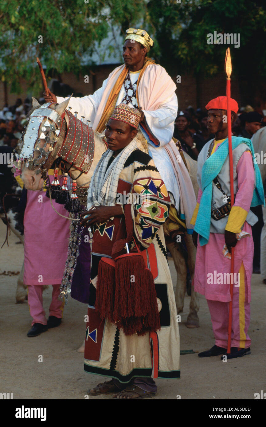 Onorato capo decorata di equitazione a cavallo con accompagnatori a Durbar Maidugari in Nigeria Foto Stock