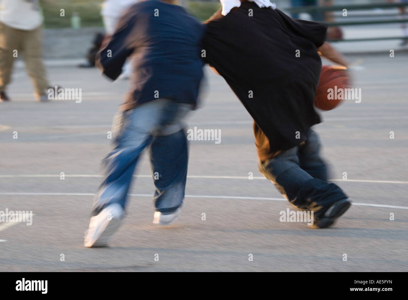Due ragazzi giocare uno contro uno basket sui tribunali della città Foto Stock