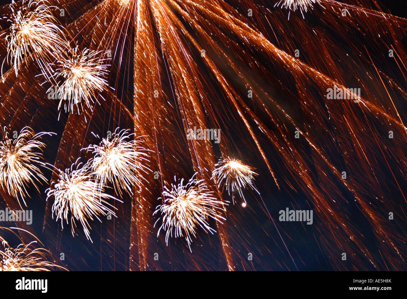 Flussi di fuochi d'artificio arancione frizzante e scintillante nel cielo notturno Foto Stock