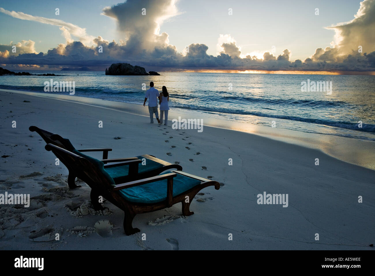 Giovane a piedi da sedie a sdraio sulla spiaggia Modello rilasciato rilasciato proprietà Cousine Island Seychelles Foto Stock