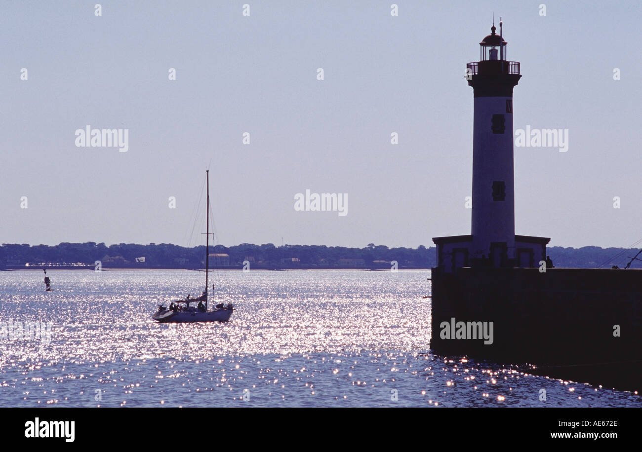 Yacht a vela vela passato un piccolo faro mentre lascia il porto di Saint Nazaire Bretagna Francia Foto Stock