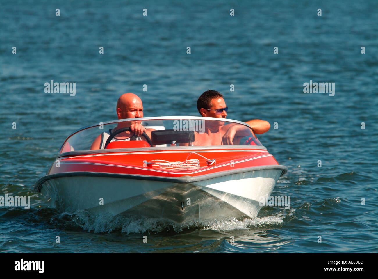Velocità rosso barca con equipaggio due maschi si fa strada lungo il fiume Avon Stour estuario a Christchurch Dorset Foto Stock