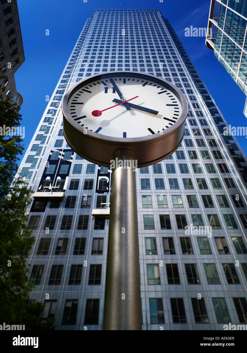 Un orologio a Canary Wharf che illustra il tempo con il grattacielo dietro Foto Stock