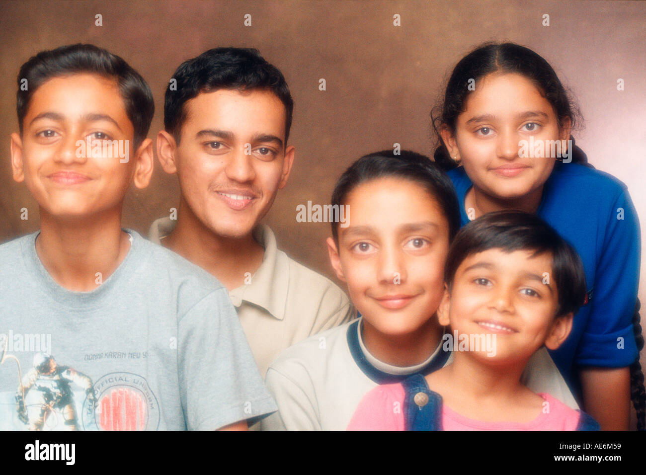RHS70981 South Asian famiglia indiana con quattro fratelli e una sorella cercando di fotocamera con sorriso modello di rilascio 518 519 Foto Stock