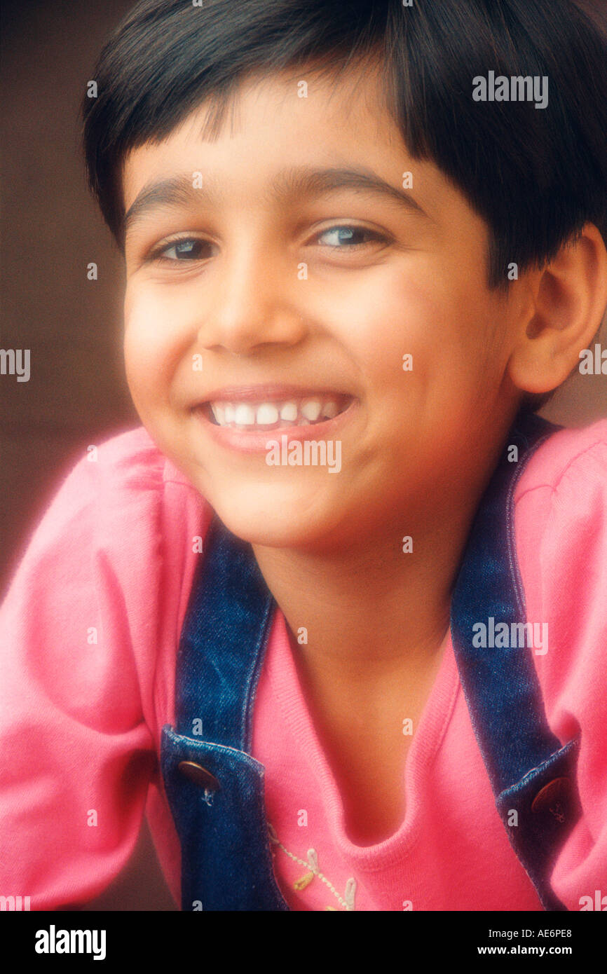 RHS70974 South Asian Indian giovane ragazzo che indossa il colore rosso T shirt blu e strisce di colore giacca con sorriso modello di rilascio 519 Foto Stock