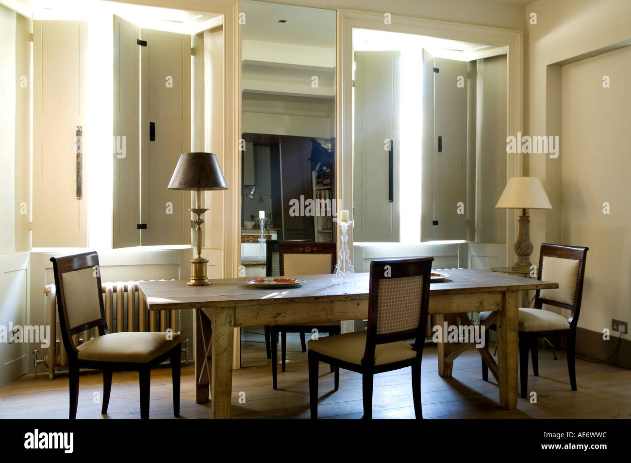 Sala da pranzo con specchio e persiane Foto Stock