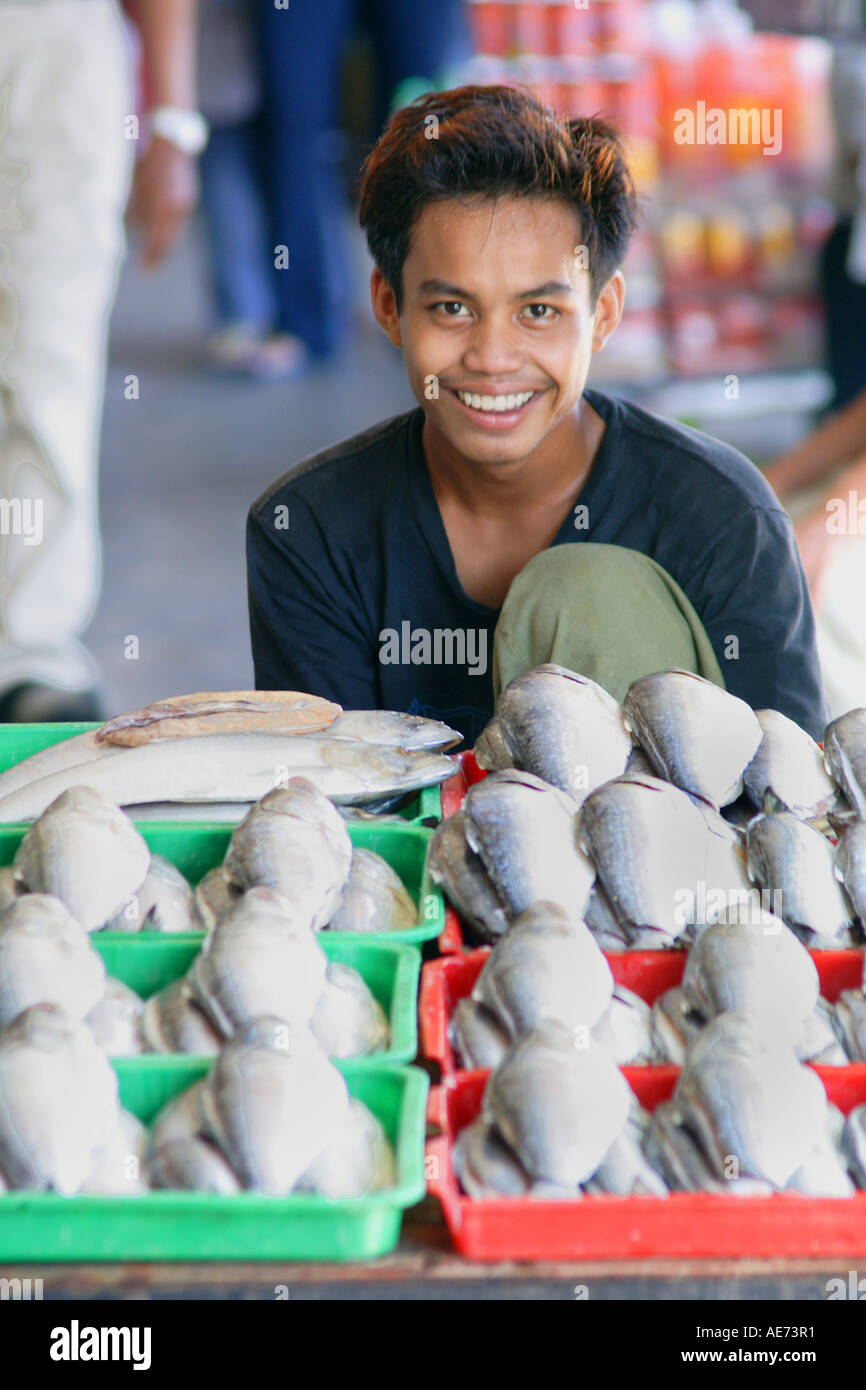 Giovane uomo di vendita del pesce nel mercato Jalal, Kuching, Sarawak, Borneo, Malaysia Foto Stock