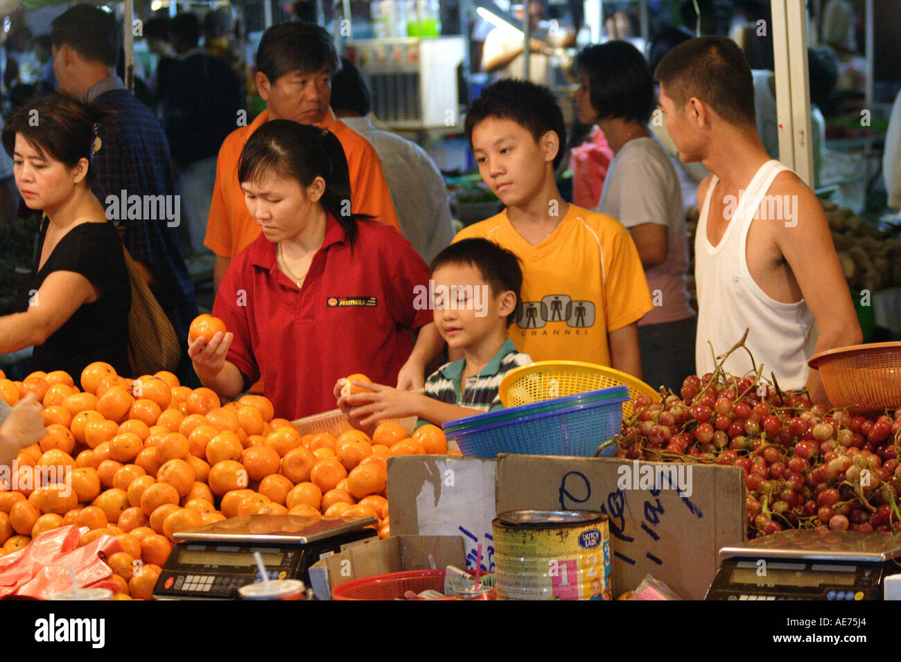 Malaysian famiglia Shopping frutta fornitori nel mercato di domenica, Kuching, Sarawak, Borneo, Malaysia Foto Stock