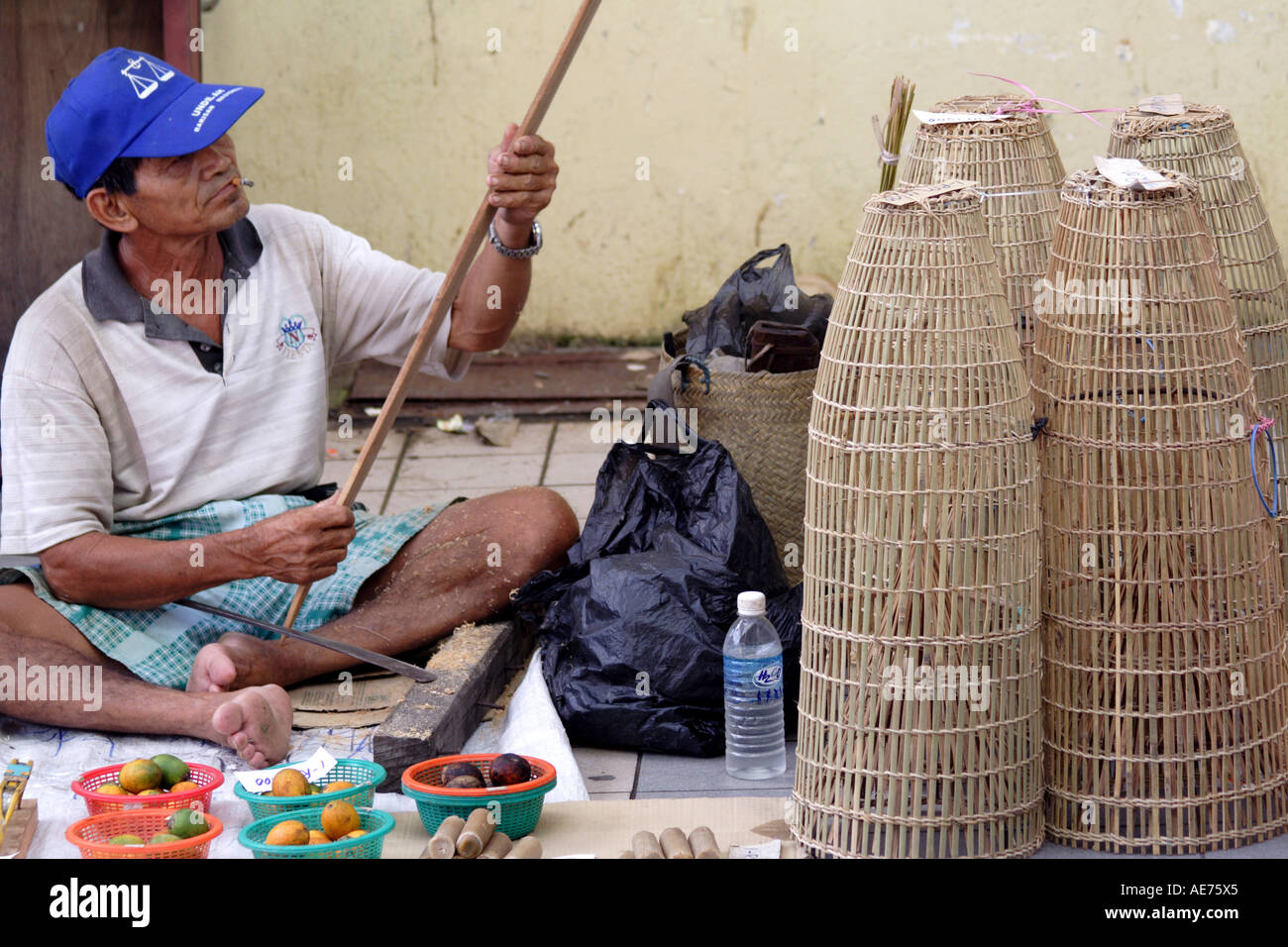 Esperto Carving una guaina per Parang, vende tessute a mano le trappole di pesce, ogni giorno di mercato nativo, Kapit, Sarawak, Borneo, Malaysia Foto Stock