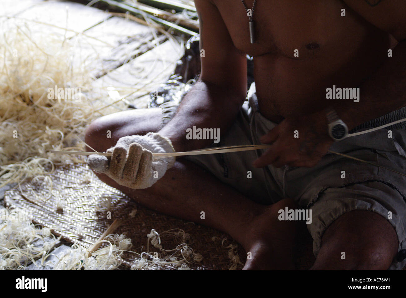 L'uomo la preparazione di fibre per lavorati a mano Mat, tessitura all'interno di Rumah Bundong, un Iban Longhouse, Kapit, Sarawak, Borneo, Malaysia Foto Stock