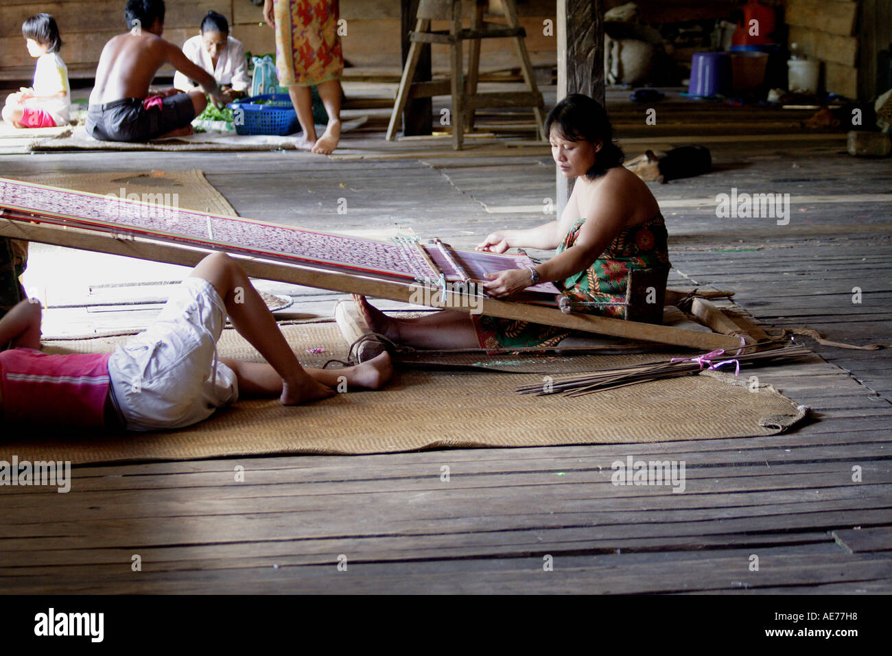 Donna tessitura a mano il cerimoniale tappeto sul telaio sul portico condivisa, Rumah Uluyong, Longhouse, Kapit, Sarawak, Borneo, Malaysia Foto Stock