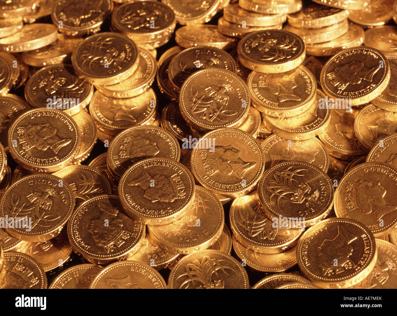 Close up di denaro nel Regno Unito una sterlina monete in contanti sotto illuminazione oro Concetto di immagine per nido uovo pila di risparmio di denaro di pile di denaro Foto Stock
