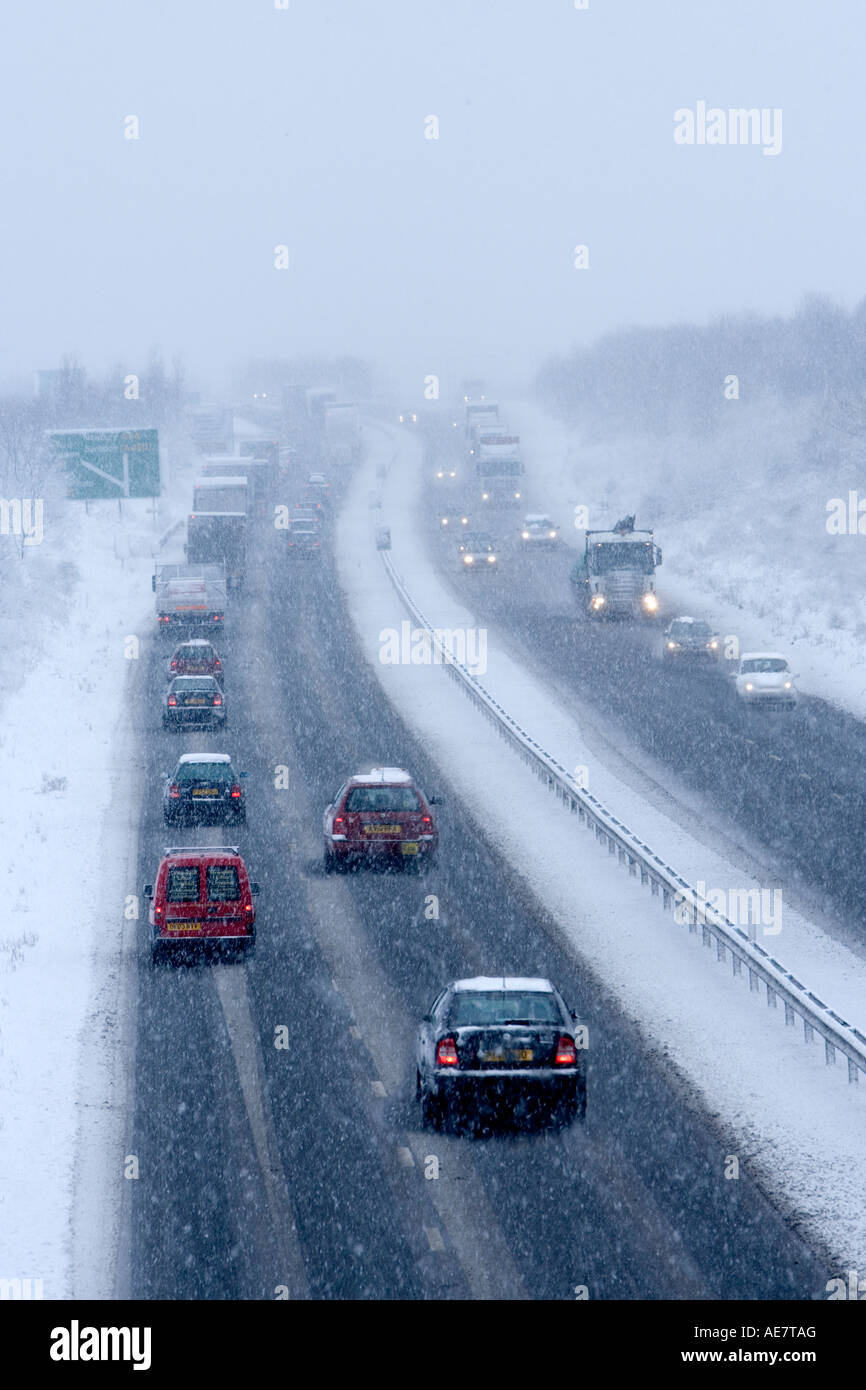 Autovetture e autocarri guida su dual carrageway in inverno la neve. Foto Stock