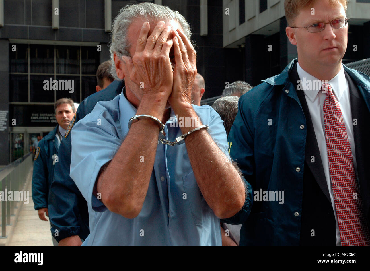 Nyc Detective di polizia e gli agenti FBI escort alcuni anziani e persone di mezza età presunta mobsters al di fuori dell'impianto di prenotazione Foto Stock