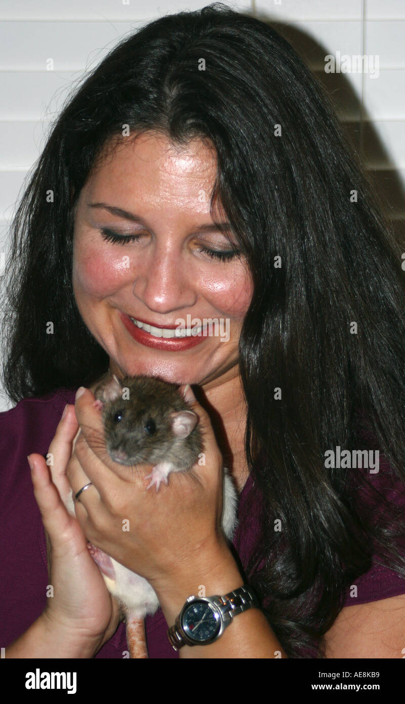 Dai capelli scuri pretty woman holding pet rat, rattie Foto Stock