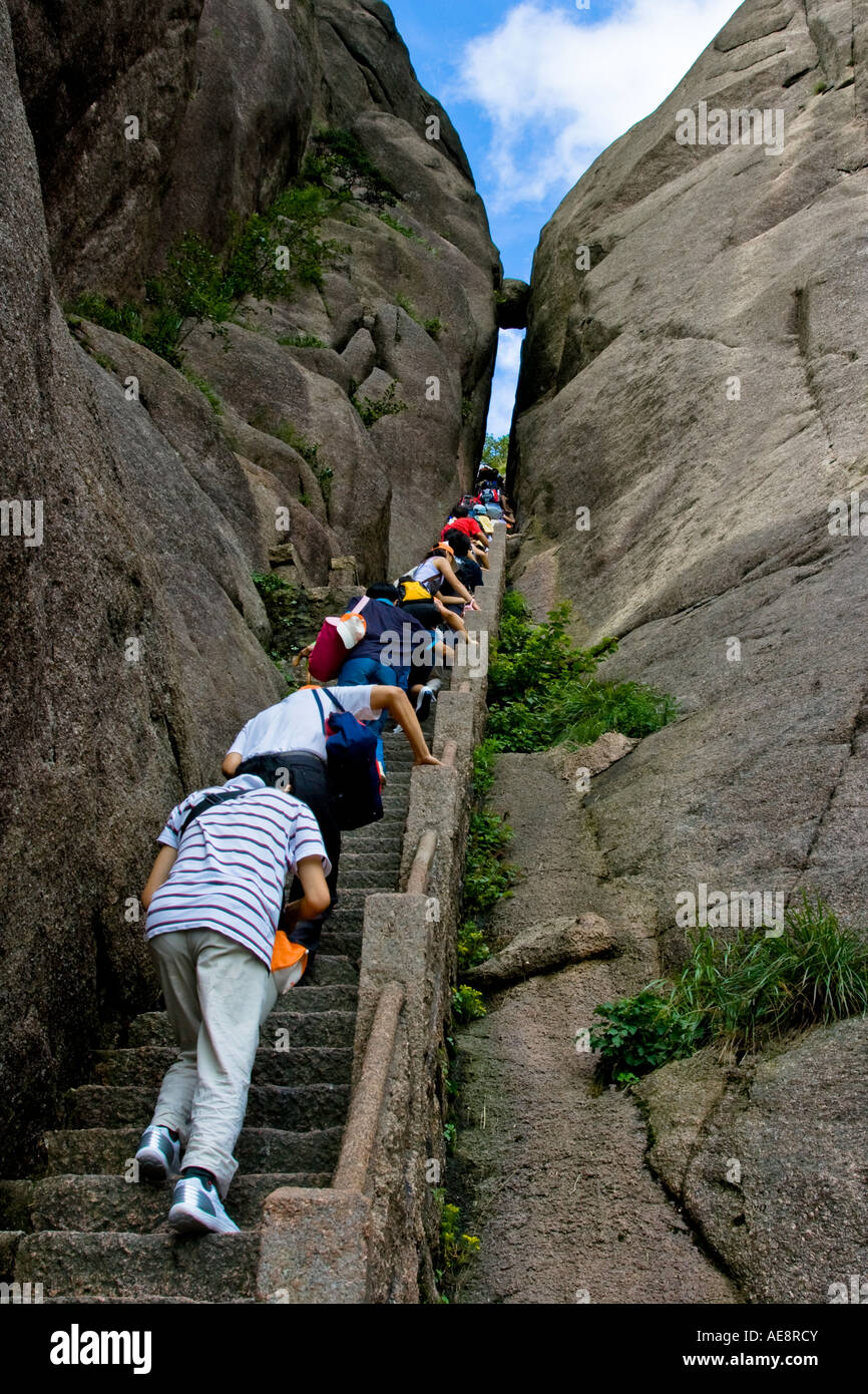 Gli escursionisti salendo le scale di pietra fino barlume di cielo verso la pietra sospesa montagne Huangshan Cina Foto Stock