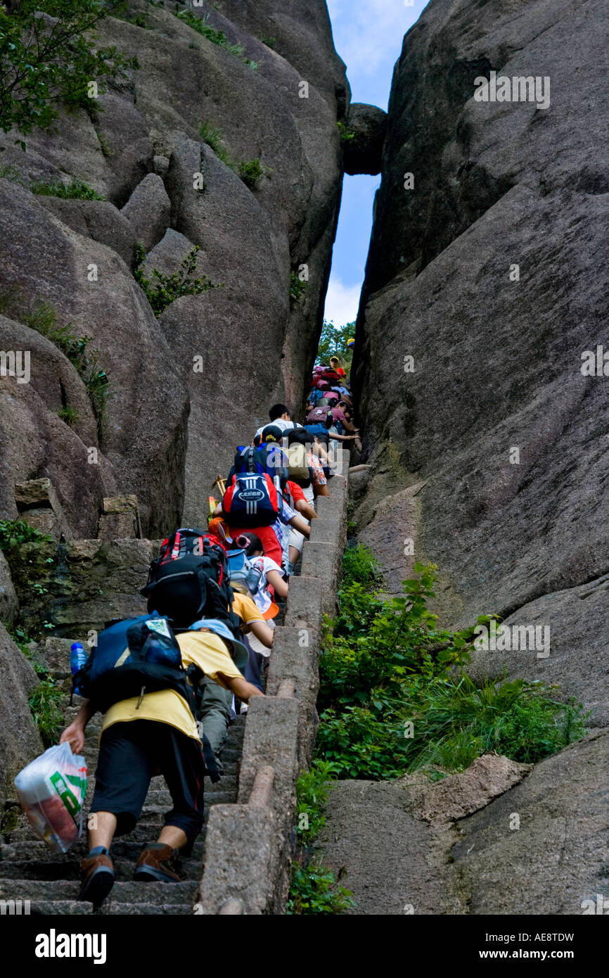 Gli escursionisti salendo le scale di pietra fino barlume di cielo verso la pietra sospesa montagne Huangshan Cina Foto Stock