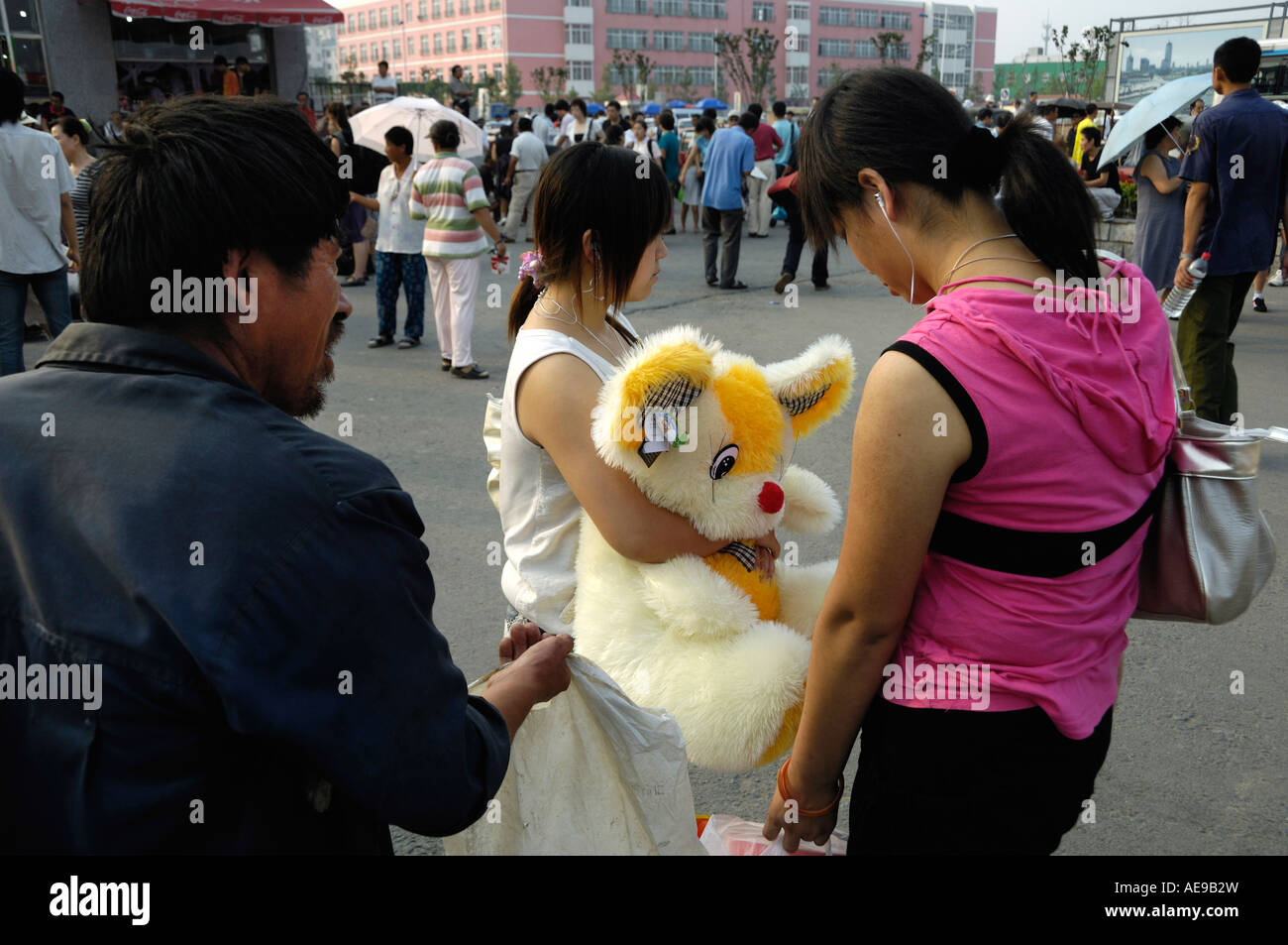 Un mendicante chiede un cambiamento di ricambio per due ragazze di Tianjin Cina 19 Ago 2007 Foto Stock