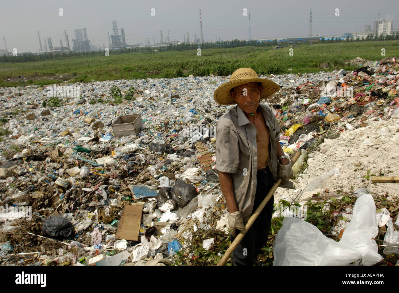 Lavoratore migrante raccoglie materiale plastico da una discarica di rifiuti in Cina il 12 giugno 2006 Foto Stock