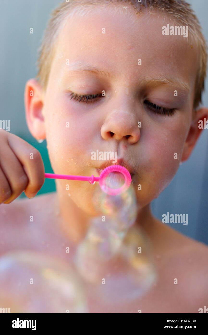 5 anno vecchio ragazzo soffiare bolle Foto Stock