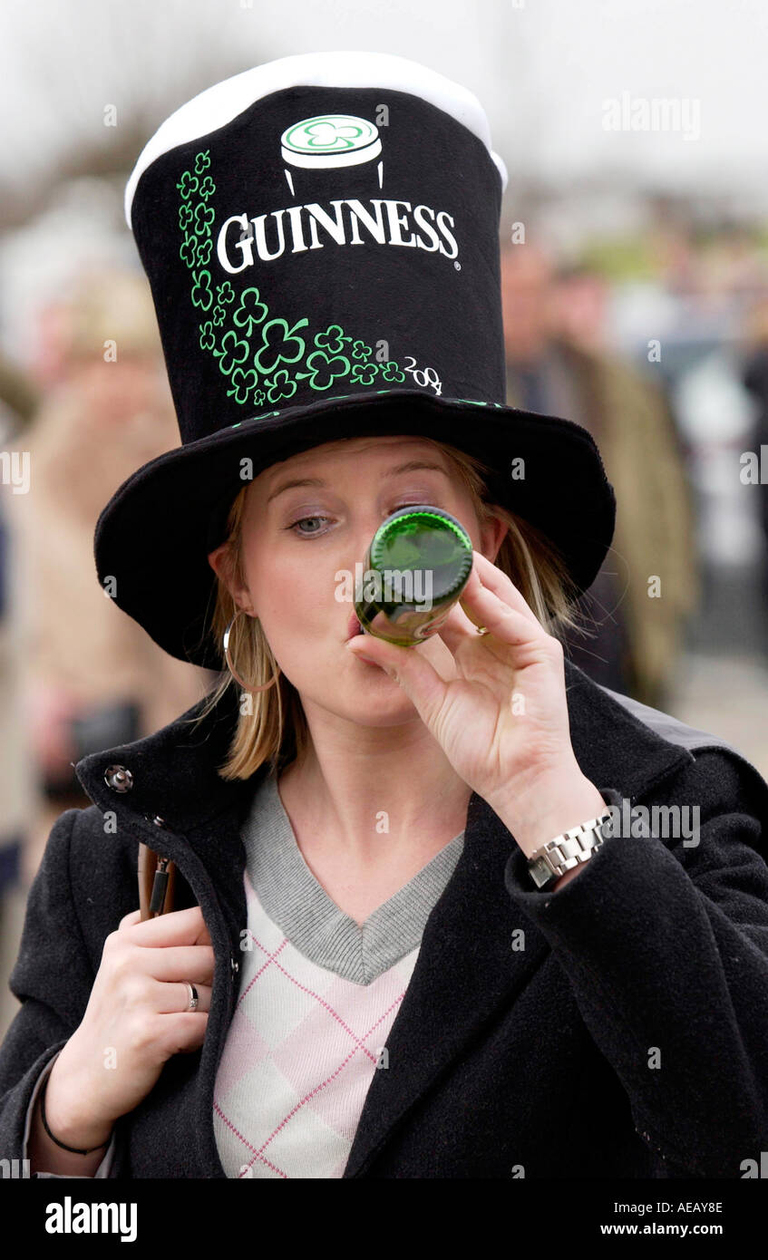 Racegoer indossa Guinness hat e beve birra Guinness alla st Patrick s Day a Cheltenham gare nazionale per il Festival di suoneria Foto Stock
