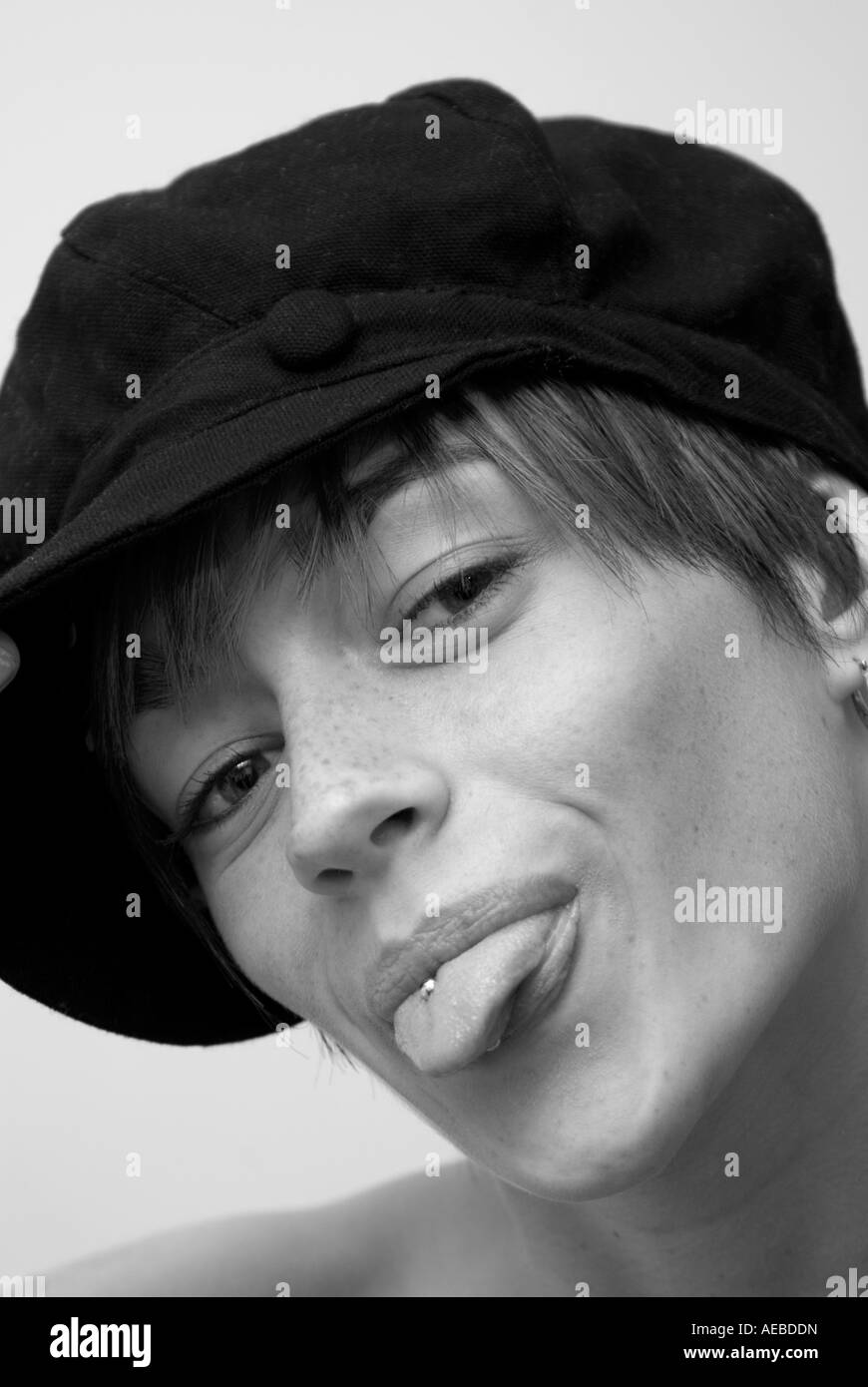 Ritratto di una giovane donna che indossa un cappello inceppato il suo trafitto con la lingua fuori Foto Stock