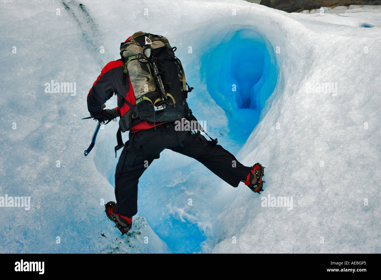 Scalatore ghiacciaio attraversando un torrente su Glaciar grigio. Parco Nazionale di Torres del Paine Cile Foto Stock