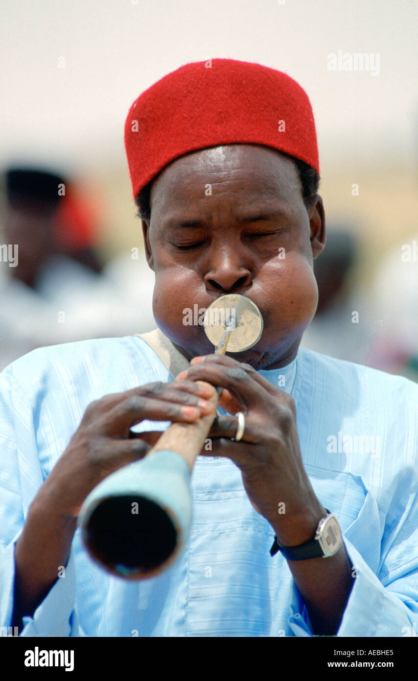 Musicista riproduzione di un tradizionale strumento a fiato Nigeria Foto Stock