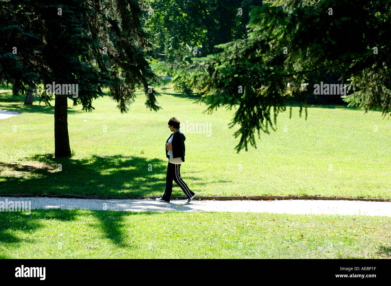 Donna che cammina in un parco in una bella giornata d'estate Foto Stock