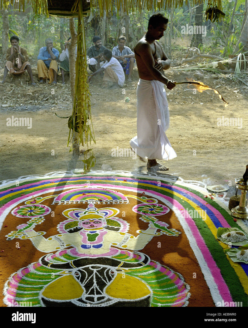 Indian sacerdote Indù di eseguire rituali in un tempio con disegnati a mano design floreale chiamato kalam in primo piano Foto Stock