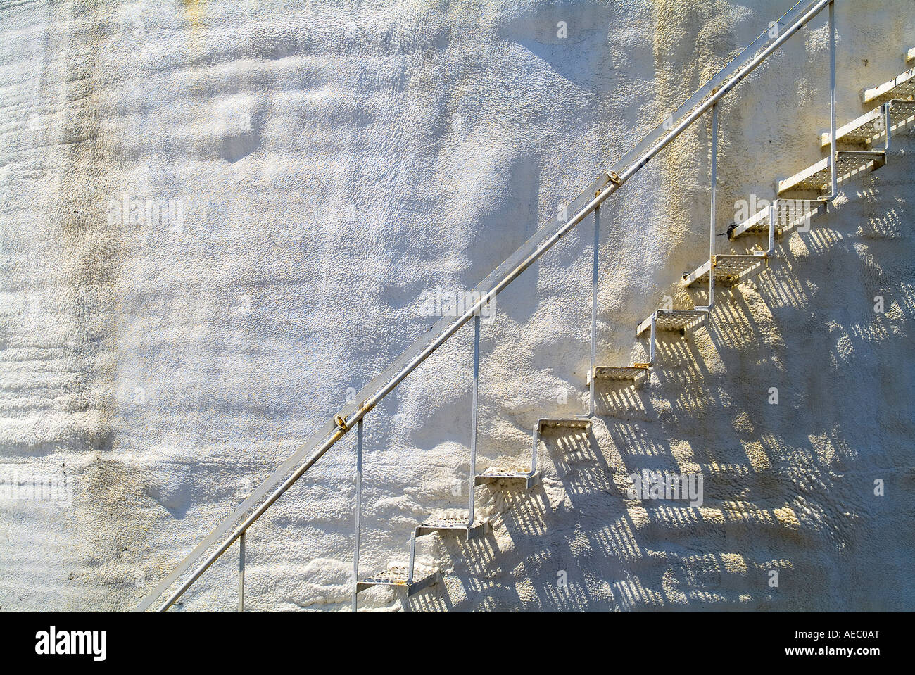 Scale di metallo sul vecchio arrugginito accidentato stucco bianco parete curva, STATI UNITI D'AMERICA Foto Stock