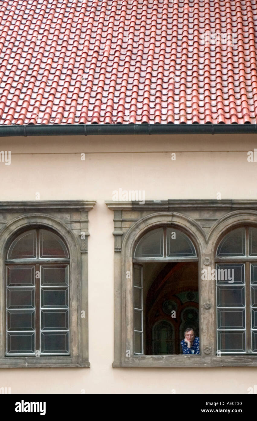 Una donna sola si affaccia una finestra di Pinkas sinagoga nel centro storico della Città Ebraica a Praga Repubblica Ceca Foto Stock