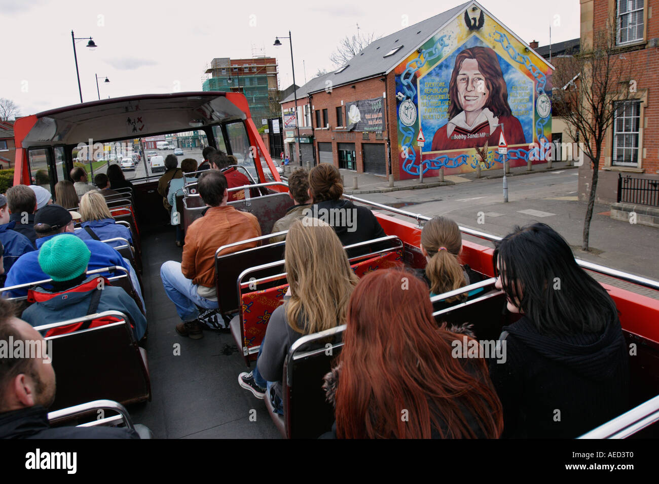 I turisti passano un murale di Bobby Sands di Falls Road a Belfast. Irlanda del Nord Foto Stock