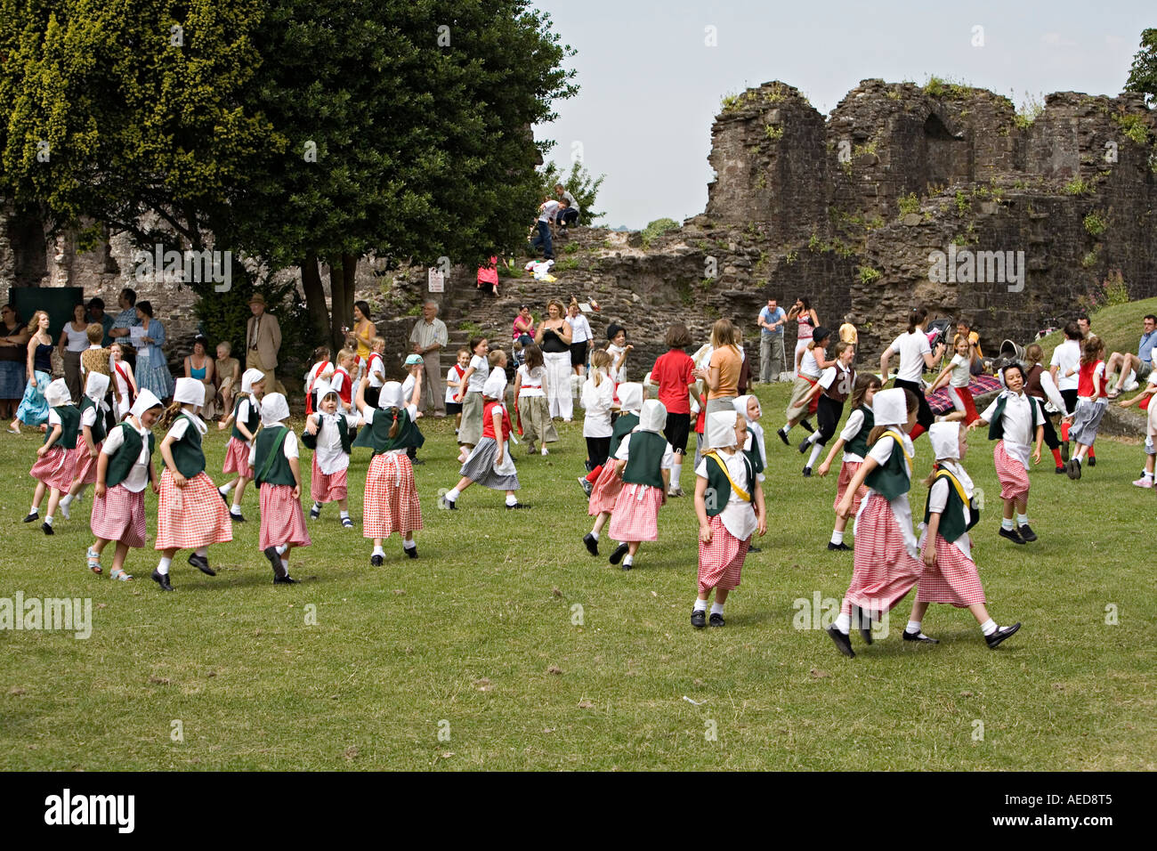I bambini in costume tradizionale country dancing in un festival in un castello in rovina motivi Abergavenny Wales UK Foto Stock