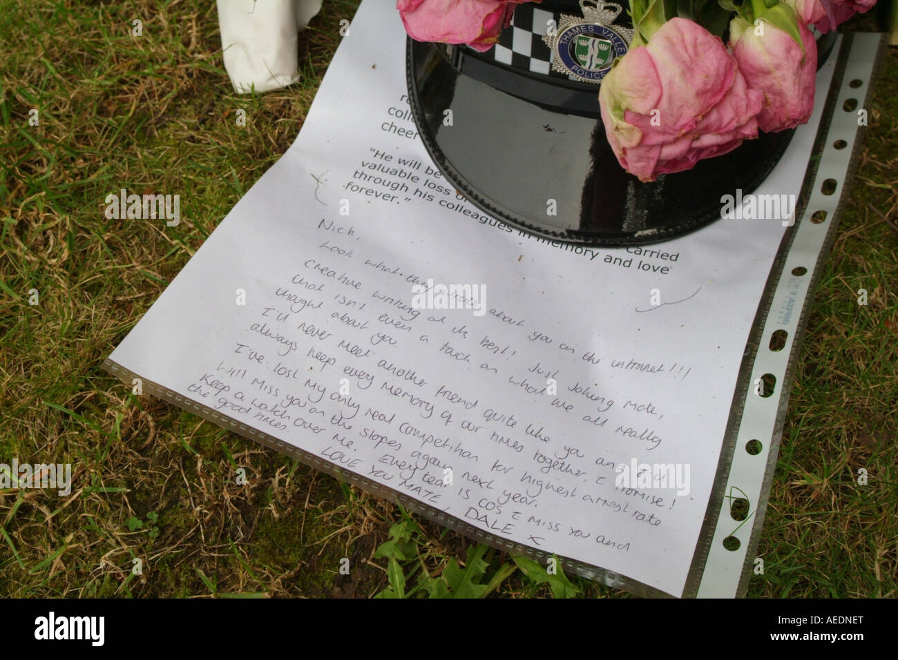 Un poliziotto del casco e un tributo scritta da uno dei suoi colleghi a sinistra vicino alla strada dove è stato ucciso in un incidente. Foto Stock