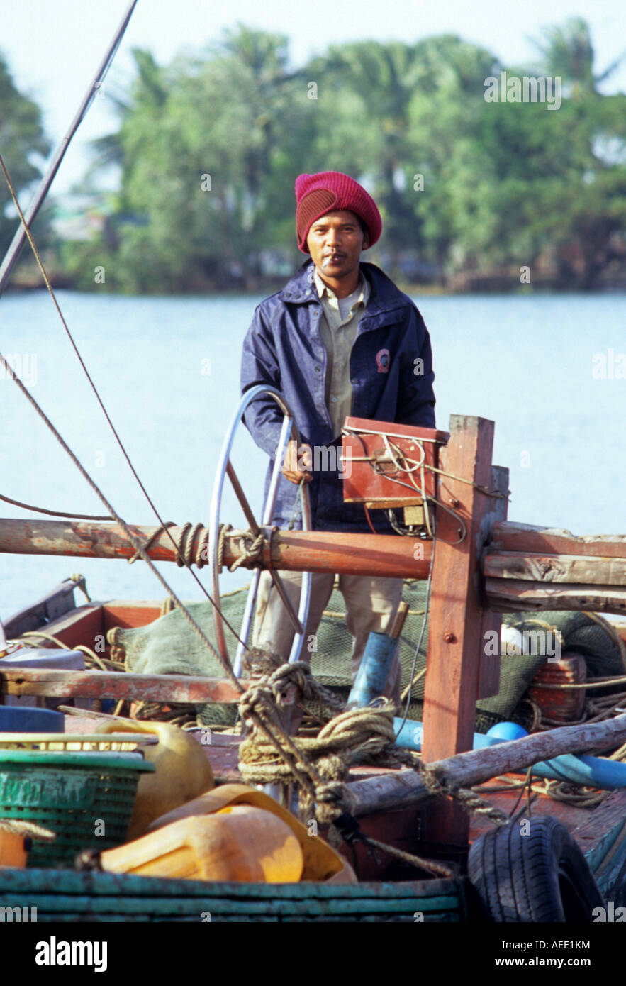 Cham pescatore in piedi la poppa di una barca da pesca sul fiume Sanke, Kampot, Cambogia Foto Stock