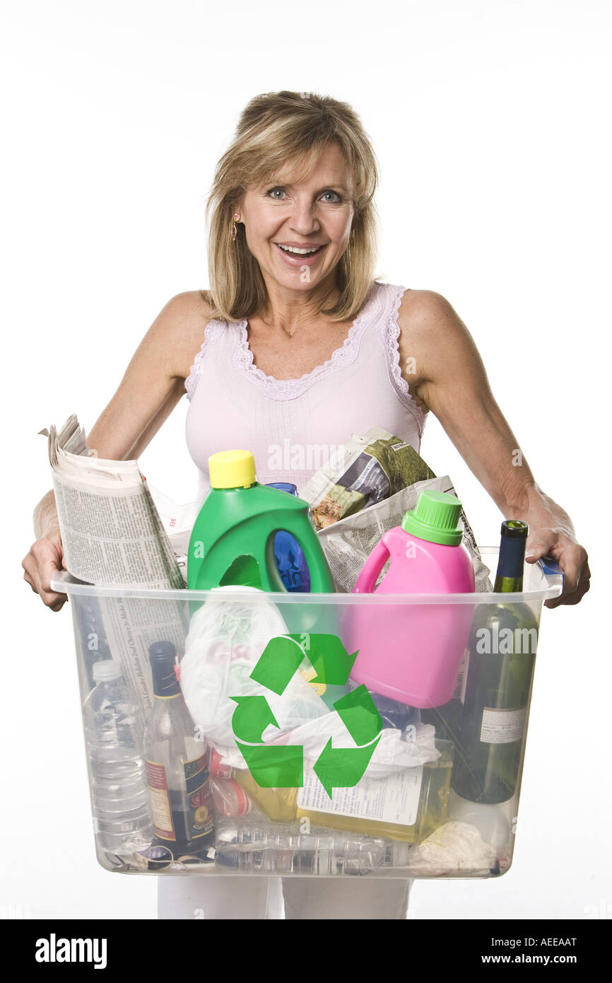 Donna che mantiene un contenitore di plastica pieno di articoli per il riciclaggio. Foto Stock