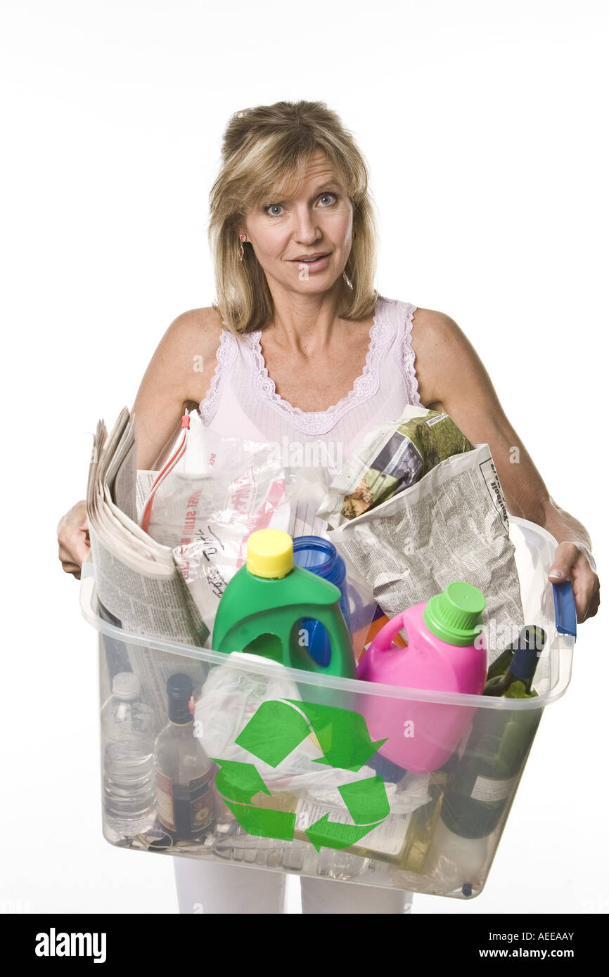 Donna che mantiene un contenitore di plastica pieno di articoli per il riciclaggio. Foto Stock