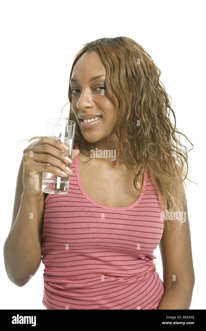 Una giovane donna tiene un bicchiere di acqua in un studio. Foto Stock