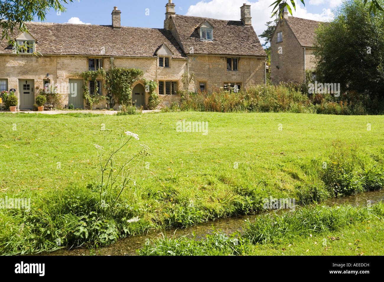 La corrente che scorre attraverso il villaggio Costwold poco Barrington, Gloucestershire Foto Stock