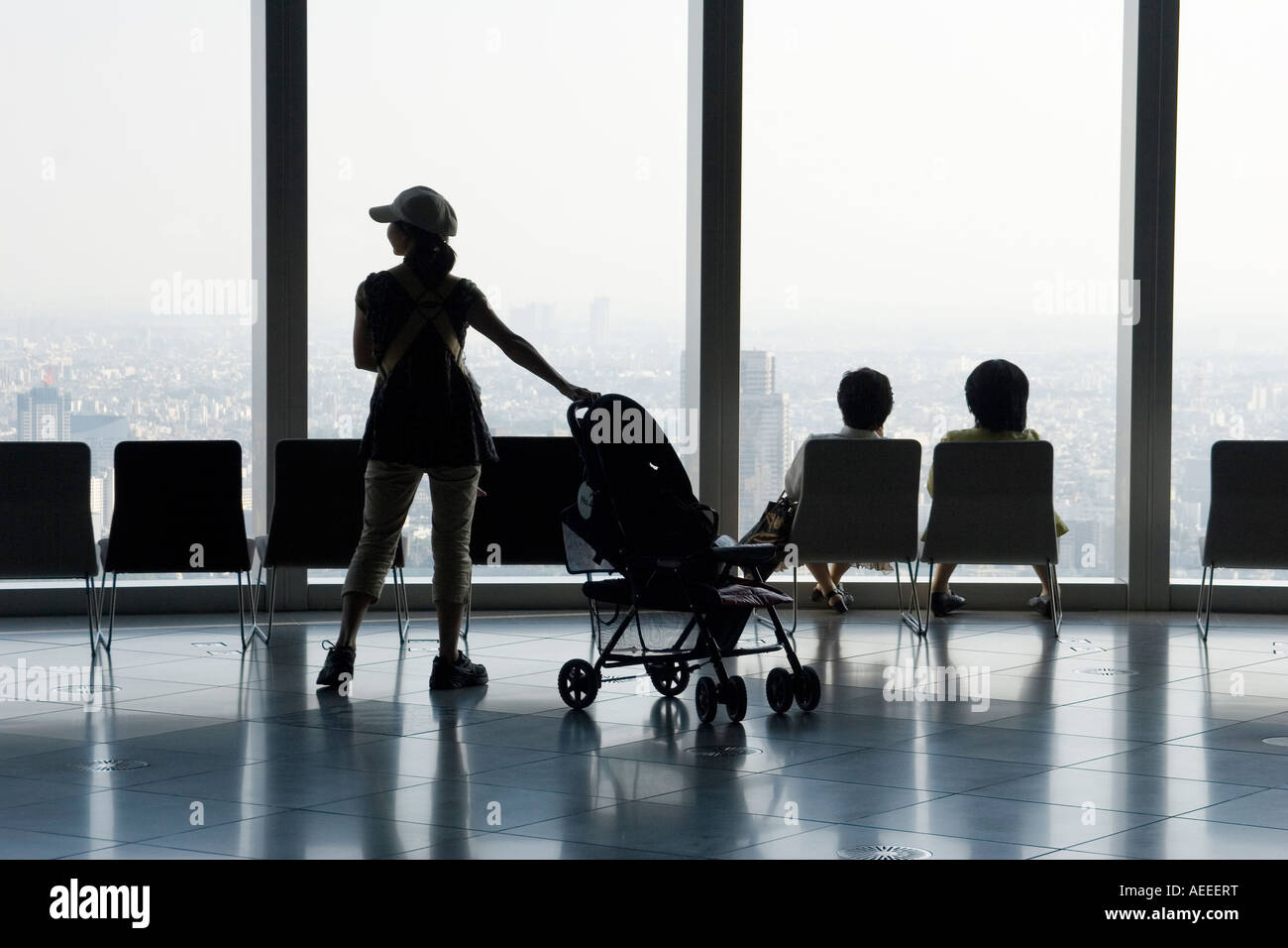 Silhouette di una donna con un bambino carrello e due donne seduti in sedie e guardando fuori una finestra immagine Foto Stock Silhouette di una donna con un bambino carrello e due donne seduti in sedie e guardando fuori una finestra immagine Foto Stock