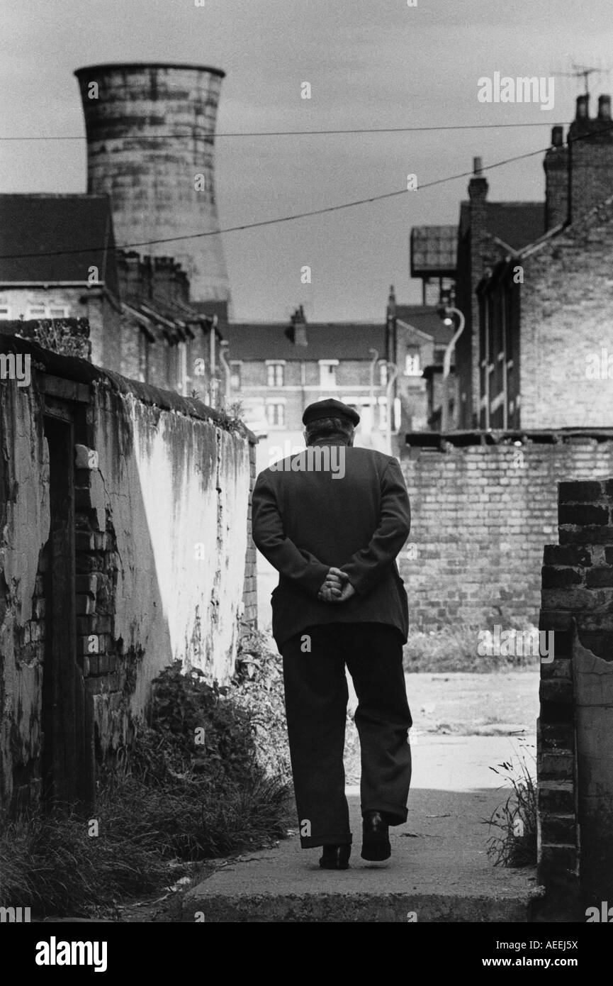 Vintage in bianco e nero scansione di stampa uomo nel tappo piatto a camminare verso il vecchio Rotherham Parkgate del gas di carbone funziona nel 1975 Foto Stock