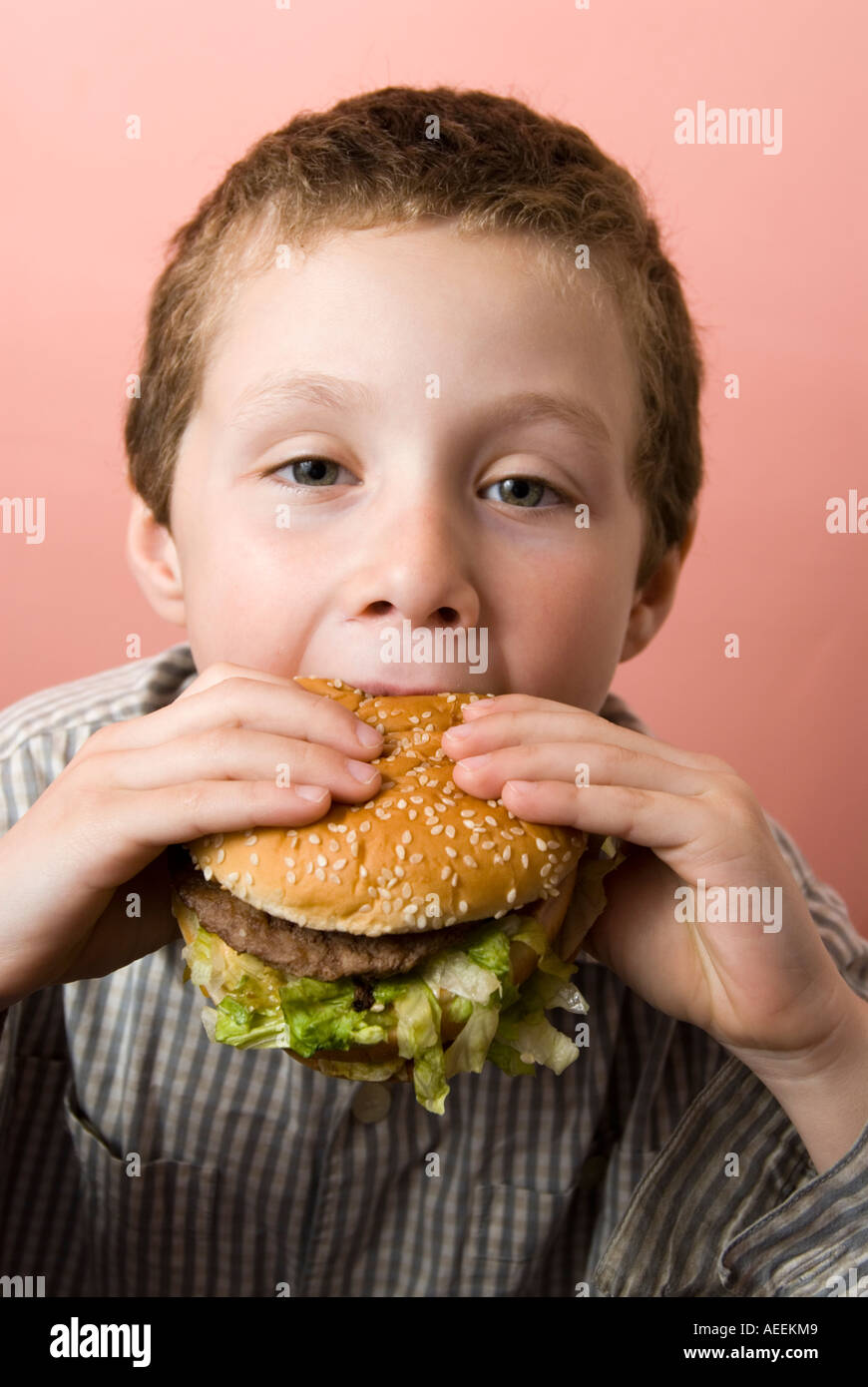 Ragazzo di mangiare McDonald's Big Mac burger, England, Regno Unito Foto Stock