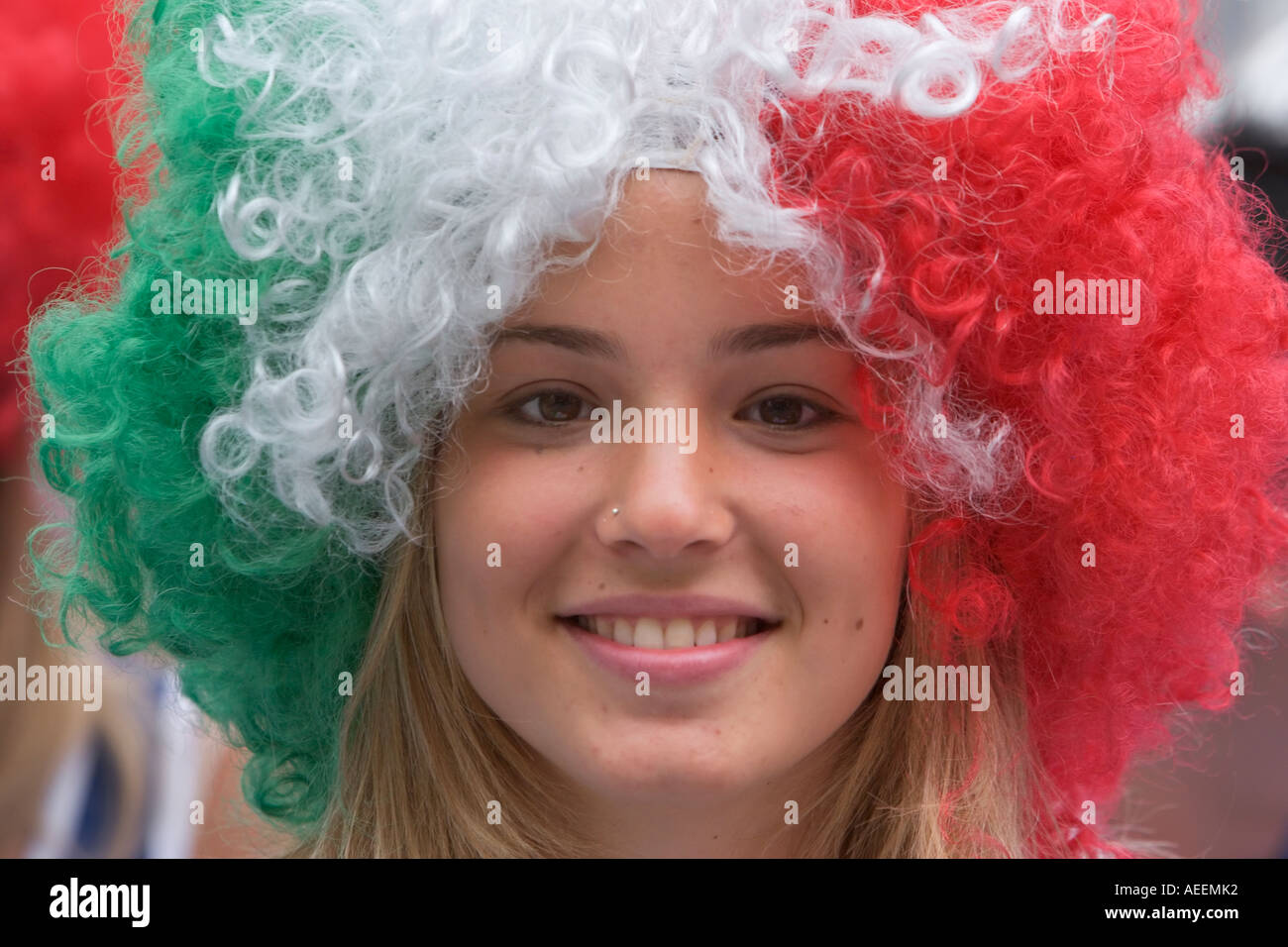 Italiano Femminile appassionato di calcio che indossa una parrucca nei suoi colori nazionali Foto Stock