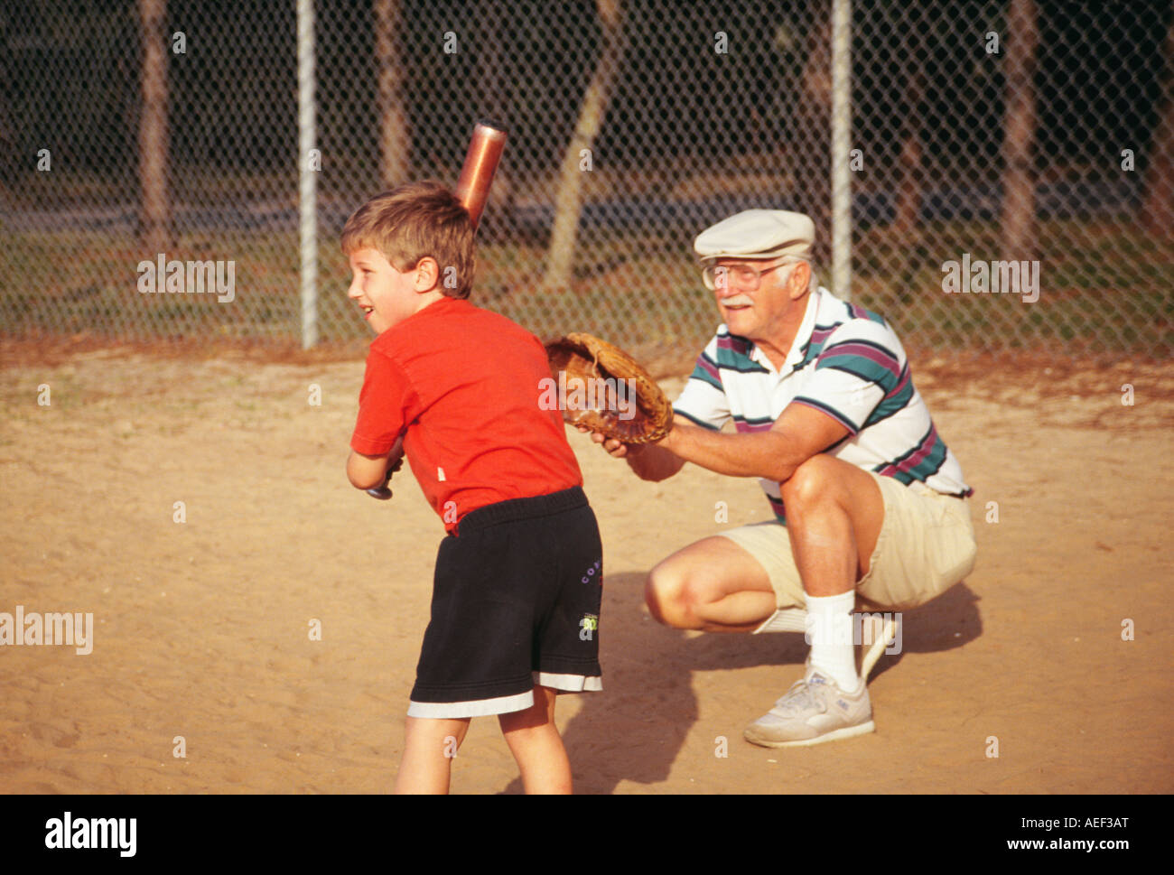 Nonno e nipote uomo e ragazzo bambini Bambino a giocare a baseball gioco su terra caucasico sorridente POV SIGNOR ©Myrleen Pearson Foto Stock