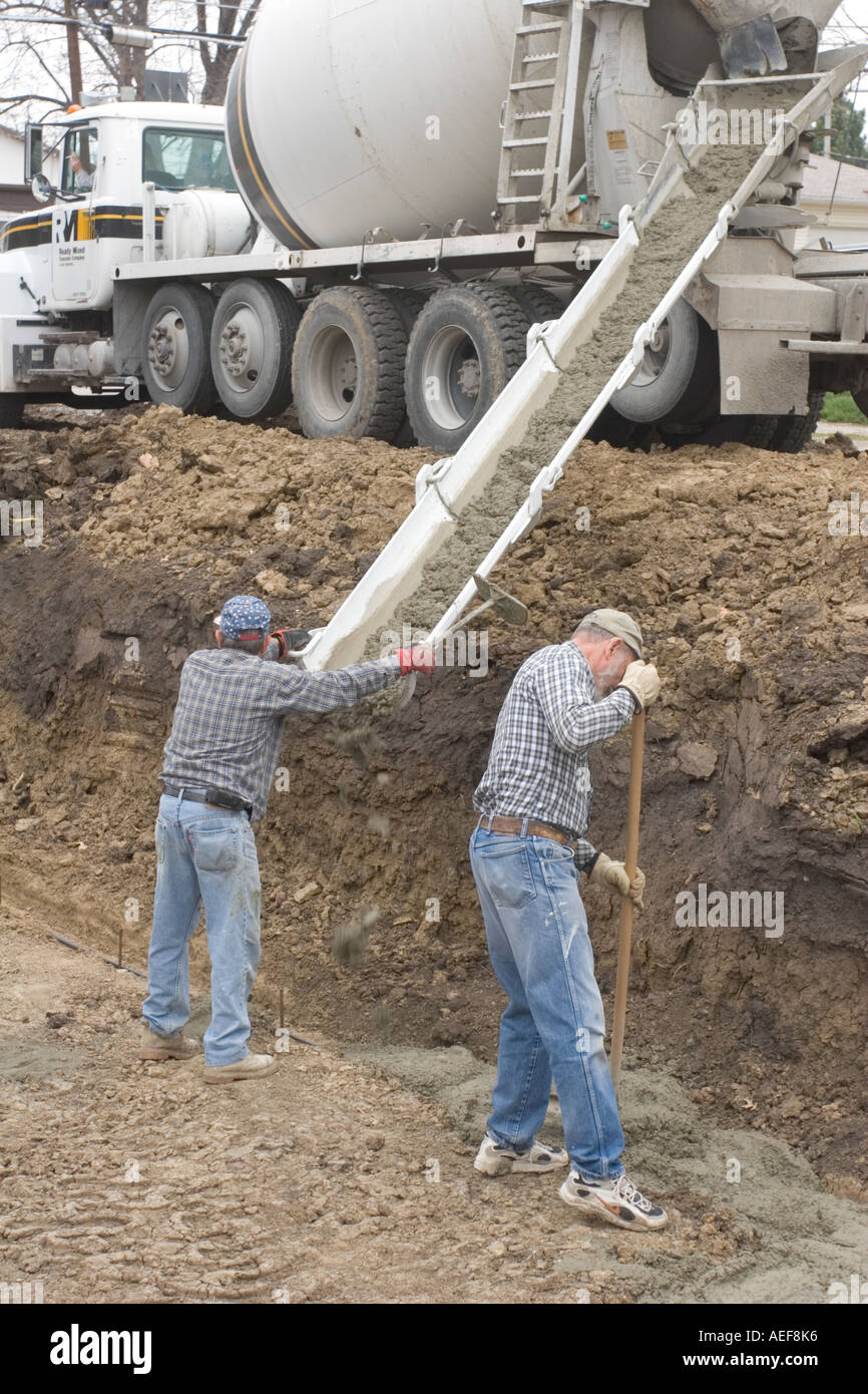 Volounteers versando la fondazione in un Habitat for Humanity sito dove una nuova casa sarà costruito per una famiglia meritevoli Foto Stock