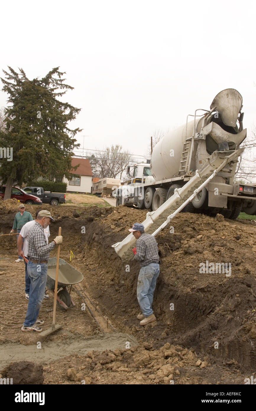 Volounteers versando la fondazione in un Habitat for Humanity sito dove una nuova casa sarà costruito per una famiglia meritevoli Foto Stock