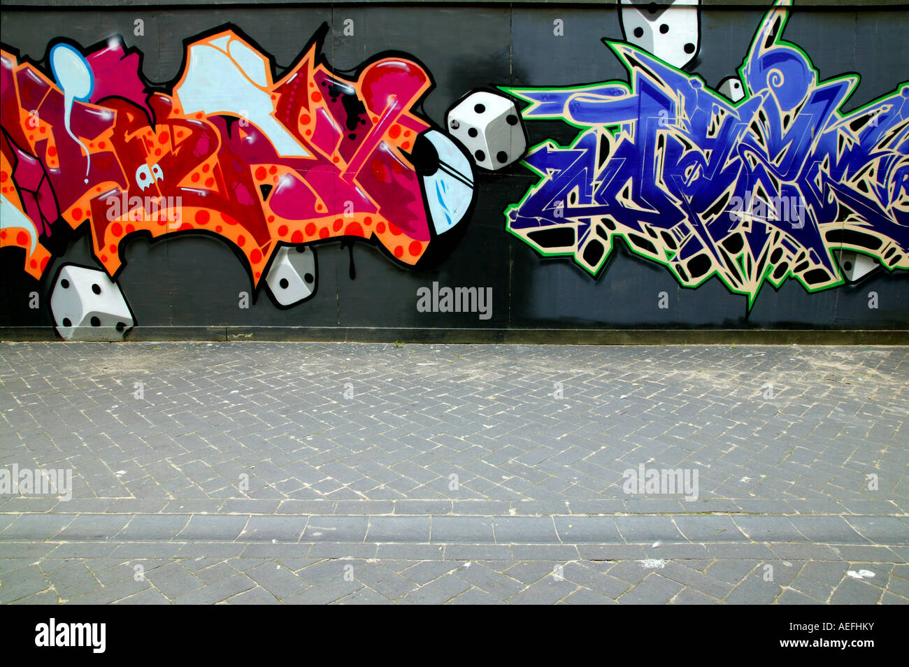 Coloratissimo graffito dipinta su un muro vicino a un sentiero pubblico da vandali Foto Stock
